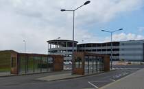 Die Bushaltestelle Belval Université am gleinamigen Bahnhof, dahinter das Parkhaus mit direktem Übergang zum Bahnhof, das besondere hierbei ist Das Parkhaus liegt in Frankreich, die Bushaltestelle sowie der Bahnhof ist luxemburgisches Gebiet. 04.2021
