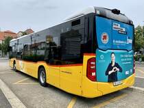 Heckansicht des MB C2 hybrid '11460' der PostAuto Regie Laupen am 3.8.21 beim Bahnhof Düdingen.