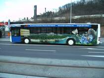 Ein MAN-Lions City der Firma Bur-Reisen die im Auftrag fr Saarbahn und Bus fhrt am Rmerkastel in Saarbrcken. Die Aufnahme des Fotos war am 05.03.2010. Auf dem Bus ist Werbung eines Saarbrcker-Energie Unternehmens zu sehen. Dieses Foto zeigt Werbung mit einem Panorama aus Saarbrcken.